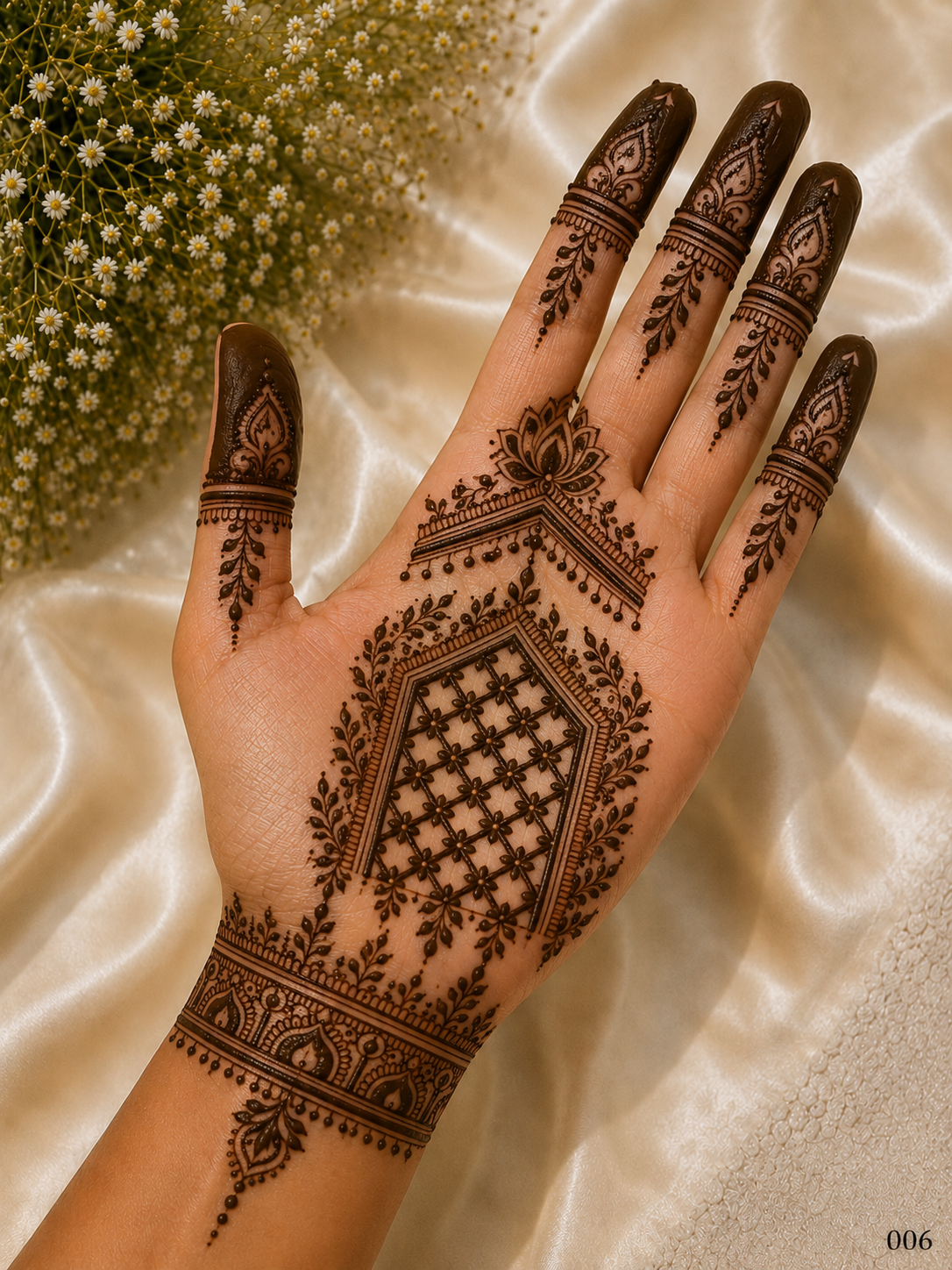 Simple front hand mehndi design featuring a lotus motif, geometric floral jaali panel, leafy borders, ornate wrist band and dark fingertips.