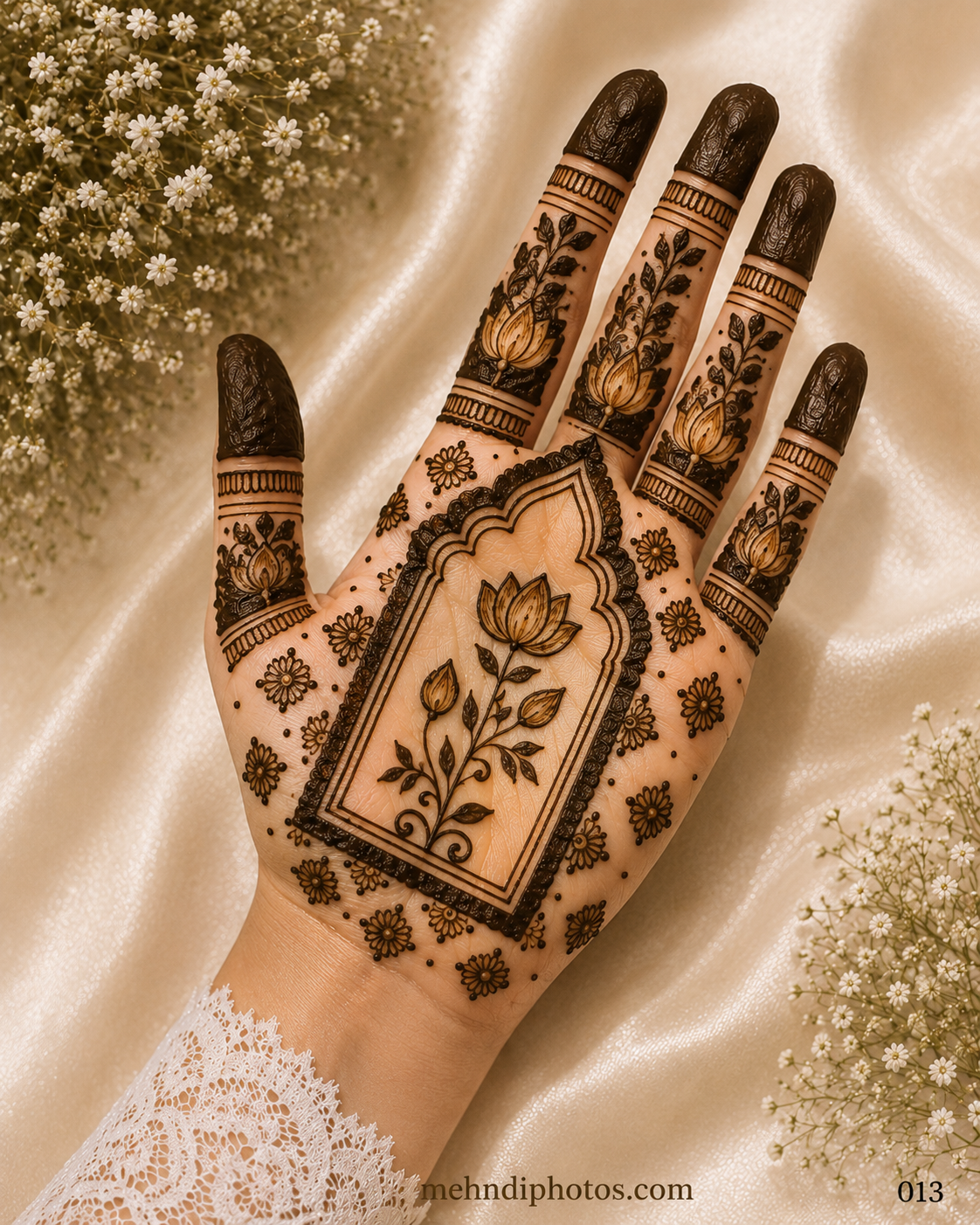 Front hand mehndi design with a lotus flower inside a temple-style arch, small floral motifs, leafy finger patterns and dark shaded fingertips.