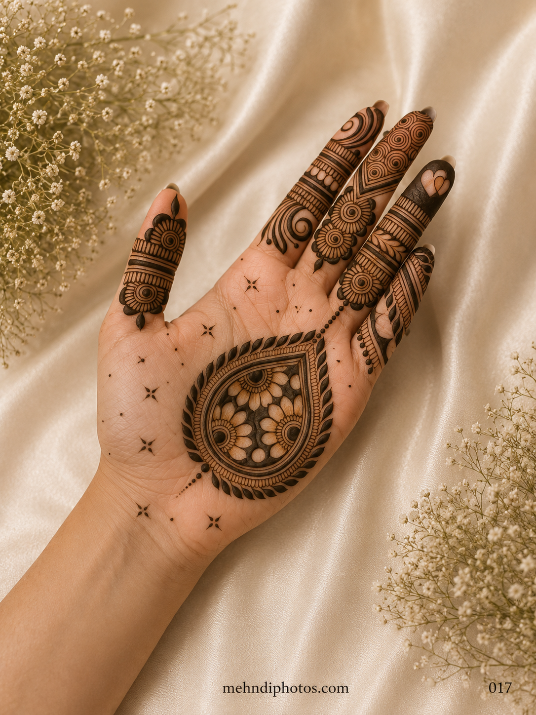 Simple front hand mehndi design featuring a large floral paisley motif, leafy border, open palm details and unique patterns on every finger.