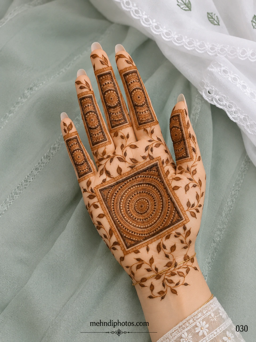 Front hand mehndi design featuring a circular mandala inside a square frame, rectangular finger panels and delicate leafy vines