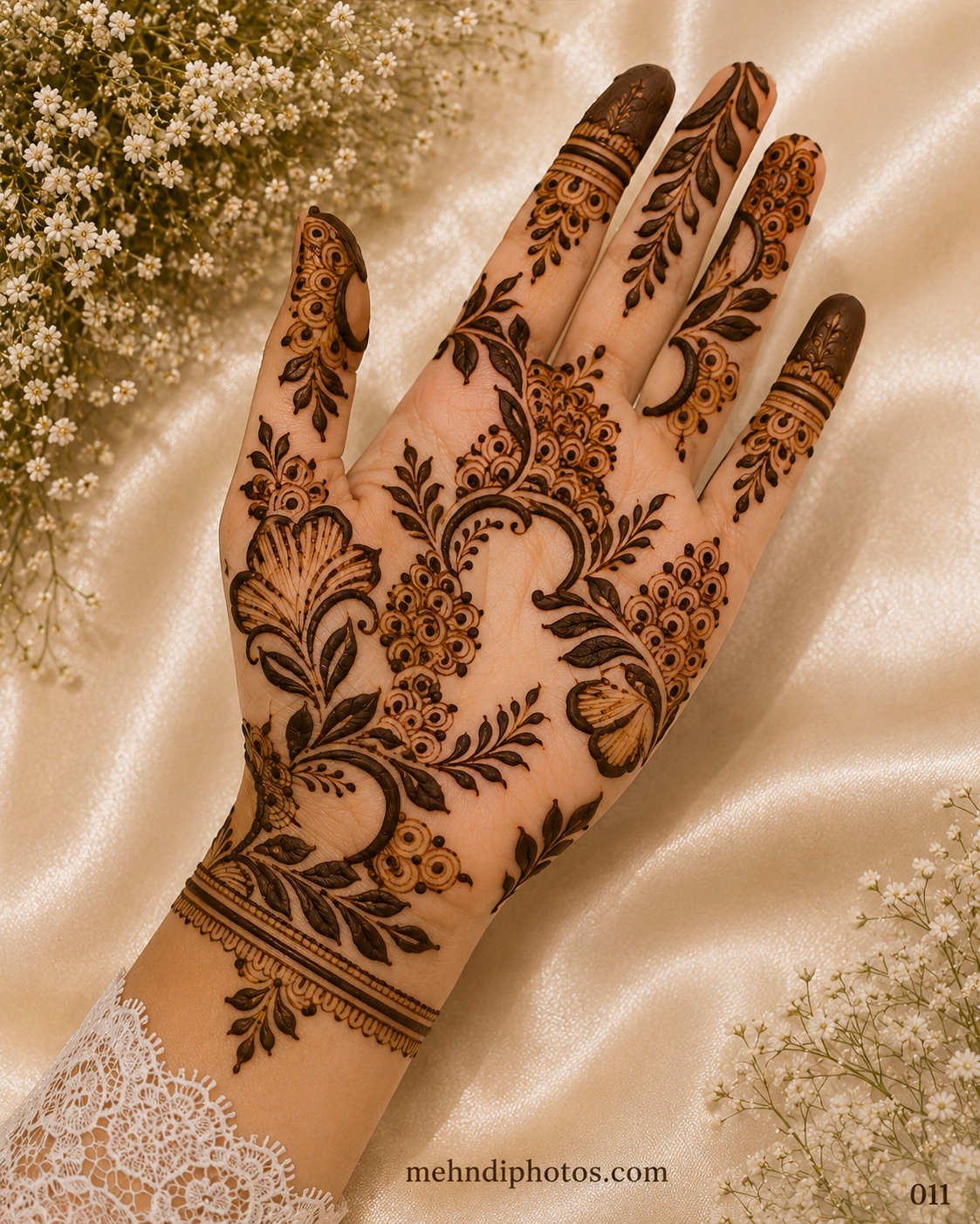 Minimal back hand mehndi design featuring a diagonal floral vine, tiny leaves and flowers with detailed ornamental patterns on the fingers.