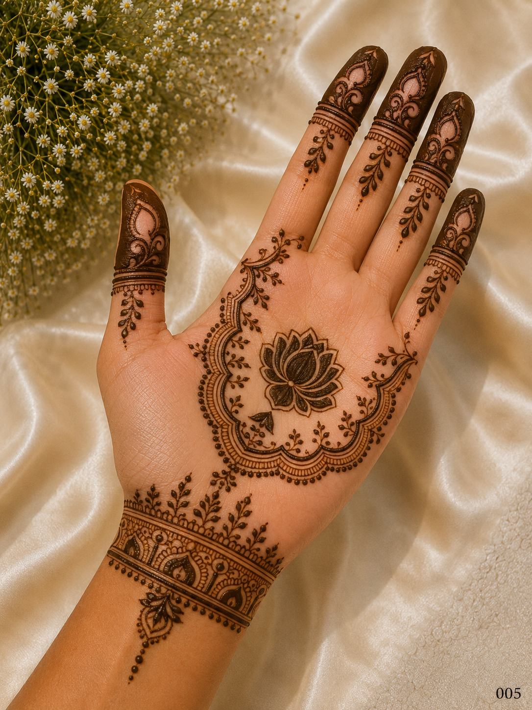 Simple front hand mehndi design featuring a central lotus motif, scalloped floral frame, leafy details, wrist bracelet and shaded fingertips.