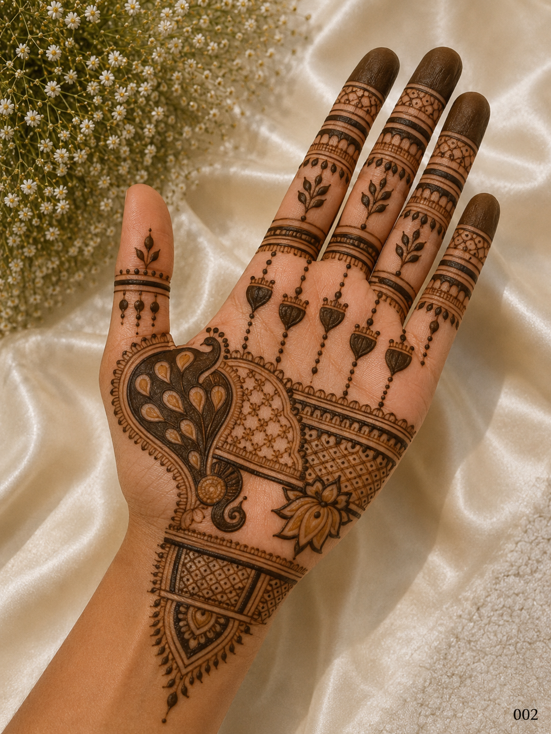 Front hand mehndi design featuring a large peacock motif, geometric jaali patterns, lotus details, hanging ornaments and dark fingertips.