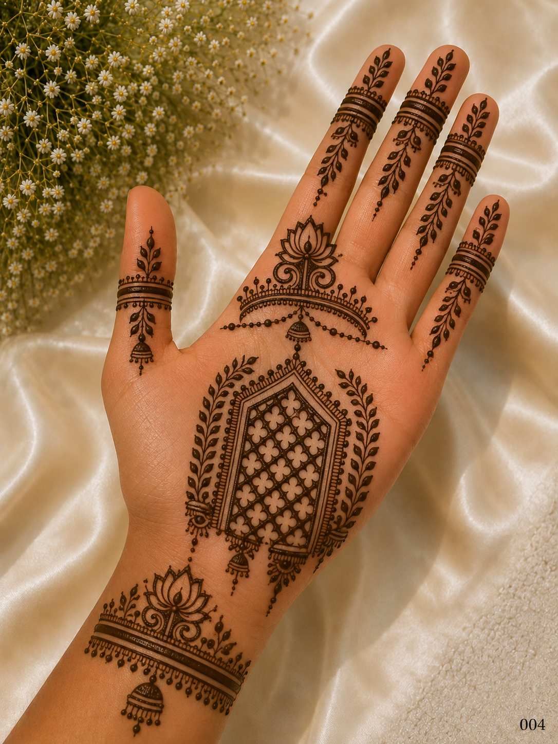 Simple front hand mehndi design featuring a central geometric jaali panel, lotus motifs, leafy borders, hanging jhumkas and decorated fingers.