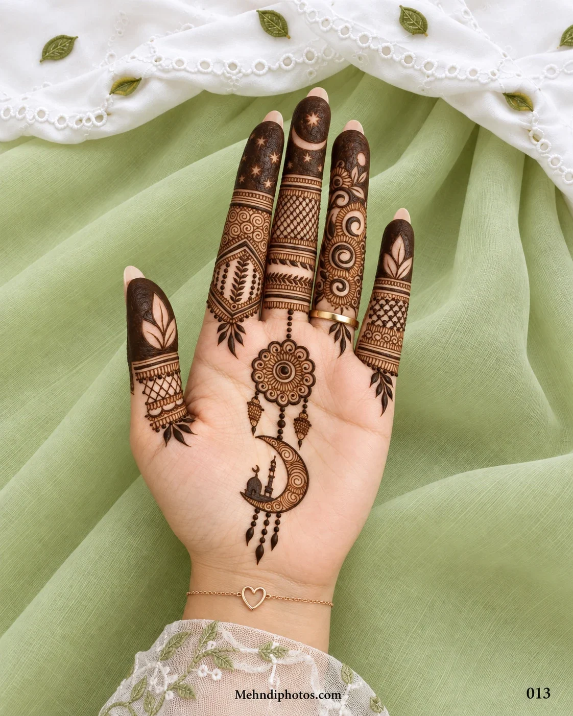 Muslim front hand mehndi design featuring a crescent moon with a mosque, hanging floral medallion, leafy details, and patterned fingers.