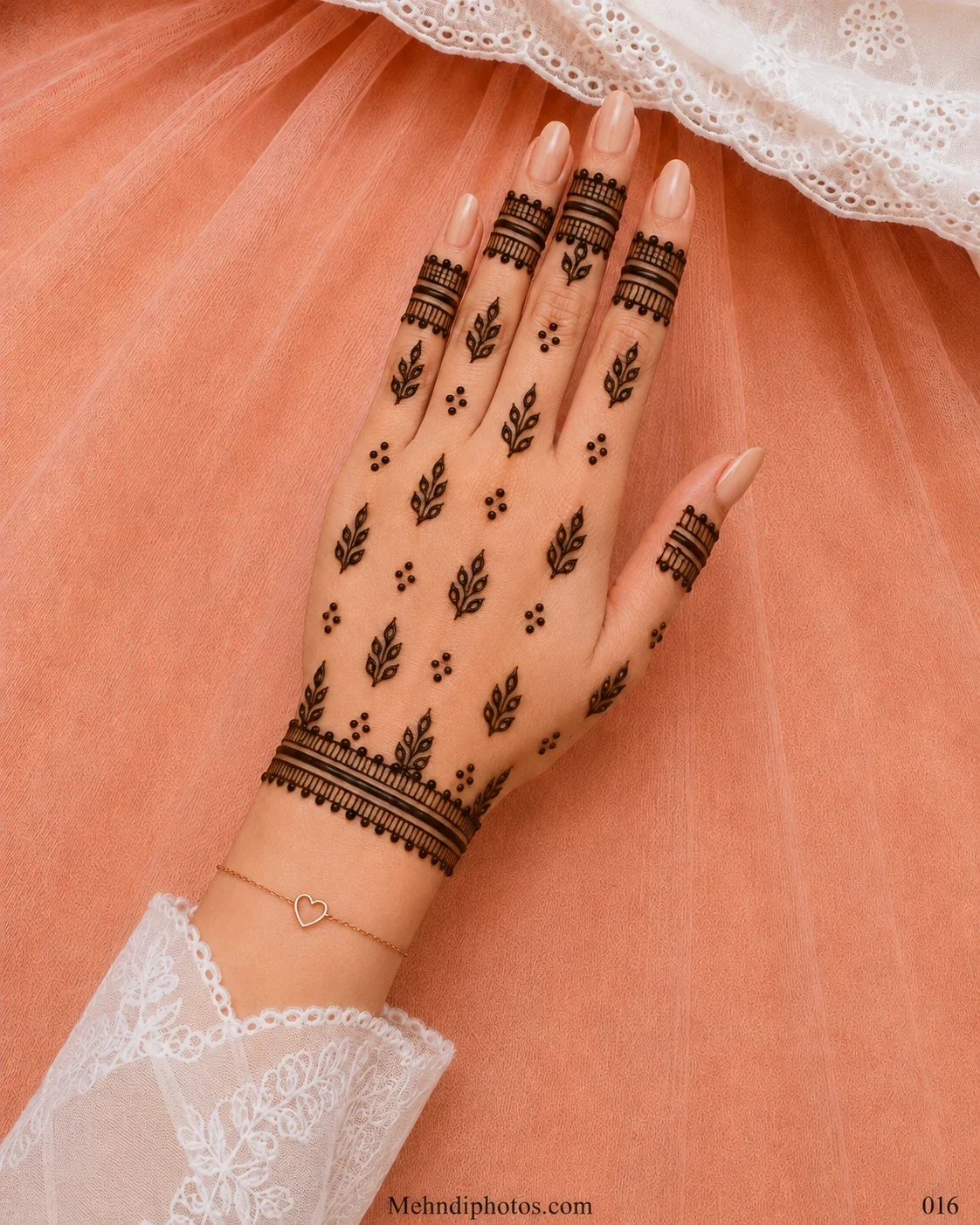 Back hand with scattered leafy mehndi sprigs, small dot clusters, bold finger bands and a matching bracelet border at the wrist.