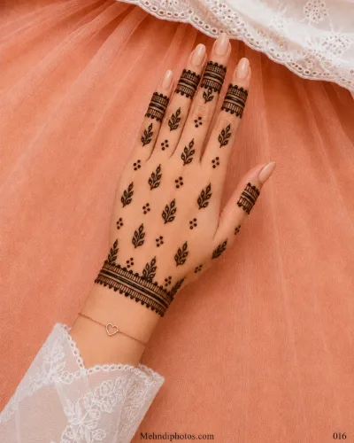 Back hand with scattered leafy mehndi sprigs, small dot clusters, bold finger bands and a matching bracelet border at the wrist.