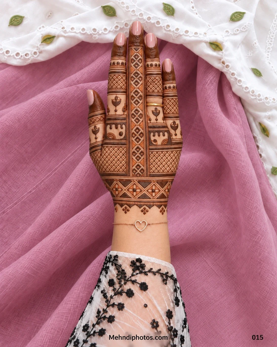 Diwali back hand mehndi design with a vertical geometric panel, small diya motifs, lattice patterns, dark fingertips, finger bands, and a decorative wrist border.