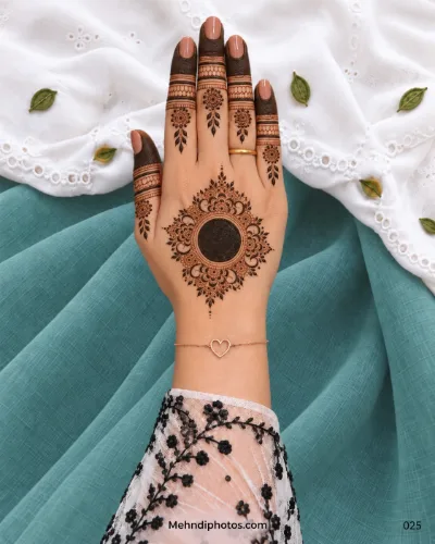 Ornate back-hand mehndi with filled gol tikki, floral lace, lattice bands, and leafy finger motifs