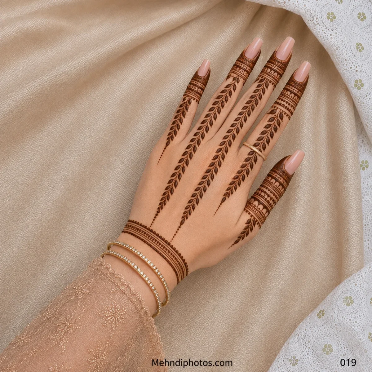 Back hand with long leafy mehndi vines, detailed ornamental finger bands, dotted trails and a bracelet-style wrist border.