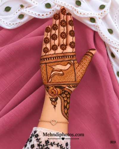 Diwali front hand mehndi design featuring a framed traditional figure, ornate peacock near the wrist, hanging sunburst finger motifs, and geometric details.