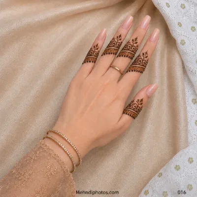 Back hand with ornamental mehndi bands featuring curved scrolls, small leafy accents and hanging dots across every finger.