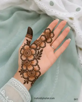 Front hand mehndi design featuring a diagonal trail of large shaded flowers with circular centres and dark leafy accents