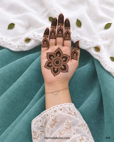 Front hand with lotus petal gol tikki and flame motif finger mehndi
