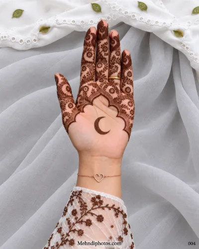 Eid front hand mehndi design featuring a crescent moon on an open palm beneath a scalloped arch filled with floral vines, leaves, and paisley details.