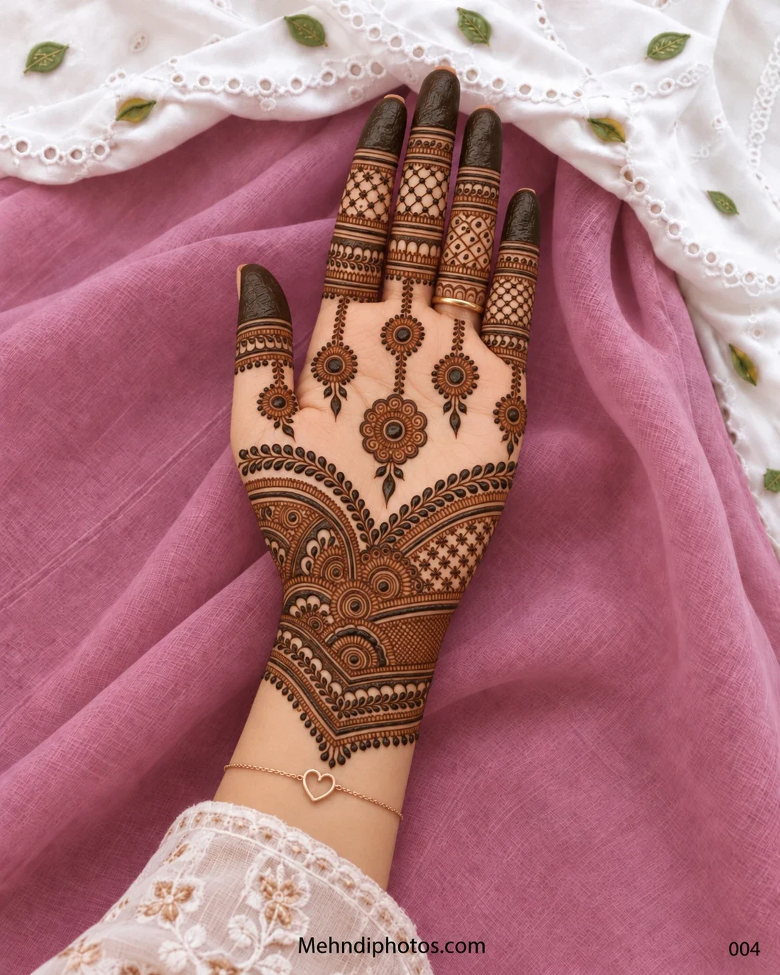 Diwali front hand mehndi design with hanging circular mandalas, leafy V-shaped borders, patterned finger bands, dark tips, and detailed wrist panels.