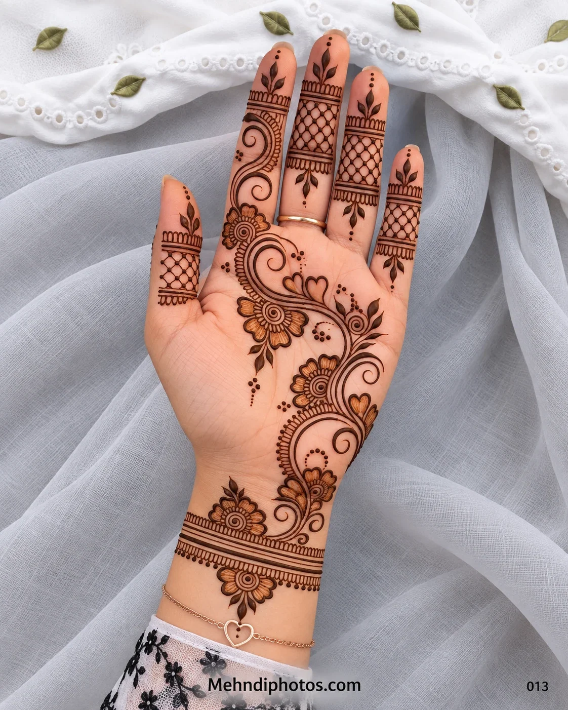 Elegant Arabic Eid mehndi with a diagonal floral vine, spiral curves, leafy accents, net finger bands, open spacing, and a floral wrist border.