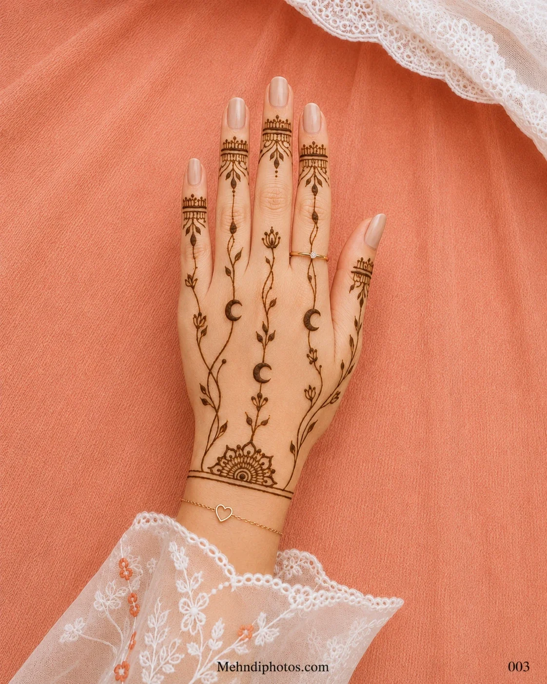 Back hand with crescent moon motifs, delicate leafy vines, ornamental finger bands and a semicircular mehndi design near the wrist.