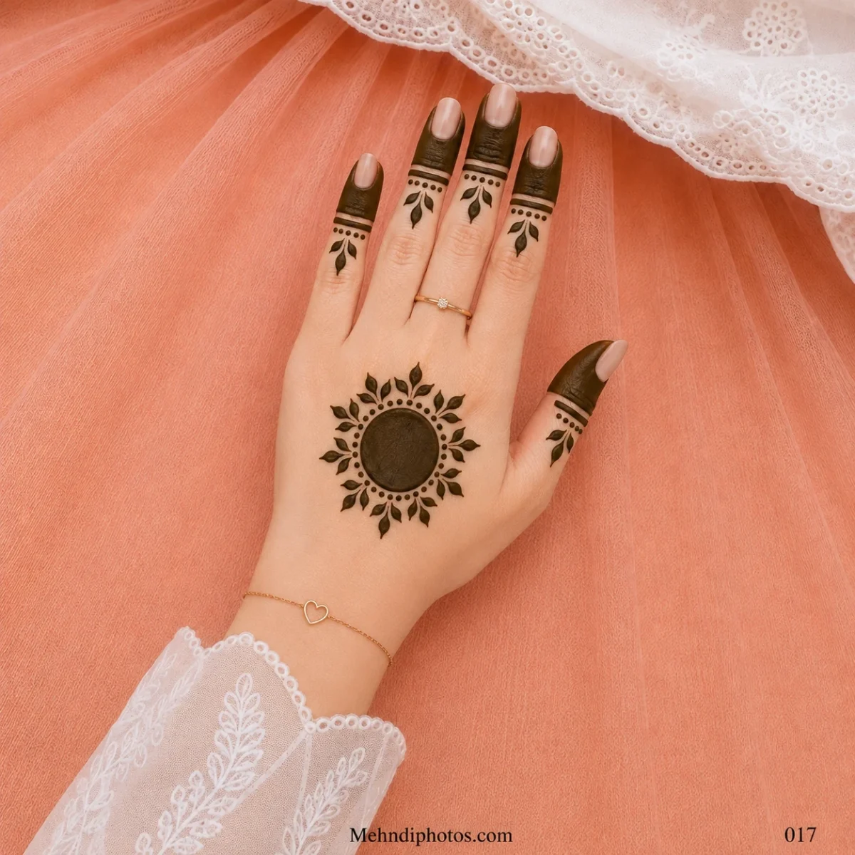 Back hand with a dark circular gol tikki, leafy dotted border, filled fingertip panels and matching leaf motifs on each finger.