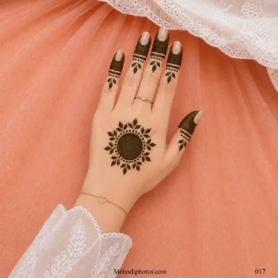 Back hand with a dark circular gol tikki, leafy dotted border, filled fingertip panels and matching leaf motifs on each finger.