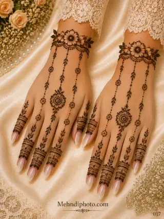 Simple back hand mehndi design on both hands with floral wrist bracelets, hanging leafy chains, central flowers and minimal finger bands.
