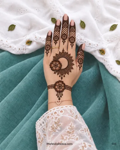 Back-hand mehndi with crescent gol tikki, shaded flowers, lattice fingers, and droplet details