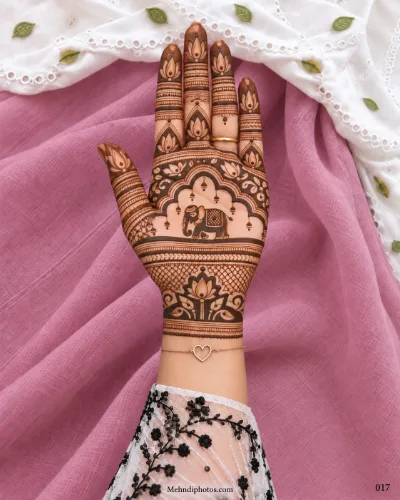 Diwali front hand mehndi design featuring a decorated elephant beneath an arch, lotus finger motifs, hanging ornaments, latticework, and a lotus wrist border.