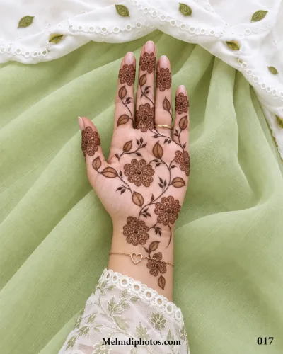 Front hand mehndi design with detailed flowers, thin curling vines, shaded leaves, and an open floral pattern extending to the wrist.