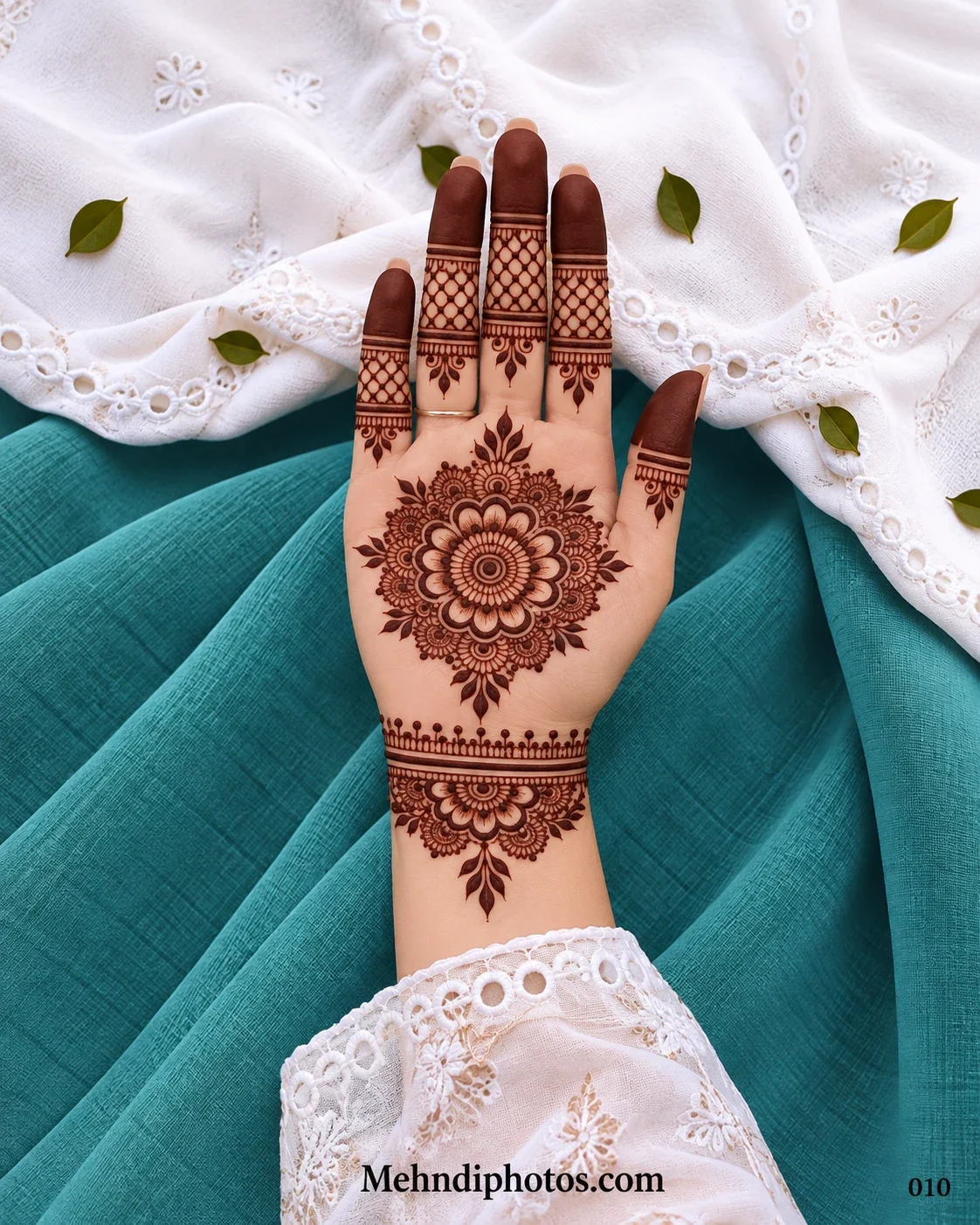 Front hand with intricate floral gol tikki, mesh fingers, and wrist band mehndi