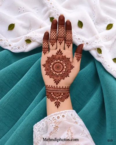 Front hand with intricate floral gol tikki, mesh fingers, and wrist band mehndi
