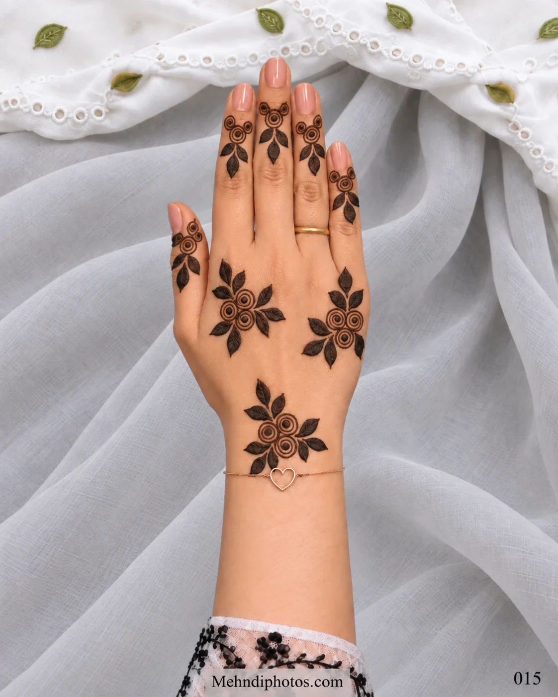 Minimal Eid back hand mehndi featuring scattered spiral rose clusters, bold leafy accents, and matching floral motifs on each finger.