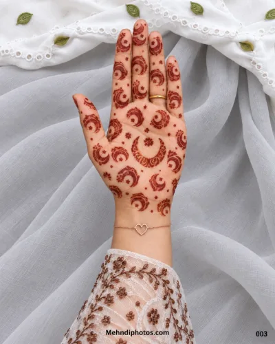 Minimal Eid front hand mehndi design featuring repeating crescent moon motifs, a larger central crescent, tiny flowers, and scattered dot accents.