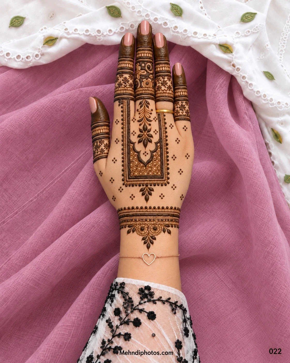 Diwali back hand mehndi design with a rectangular jewellery-style panel, leafy floral motifs, patterned finger bands, dark fingertips, and an ornamental wrist border.