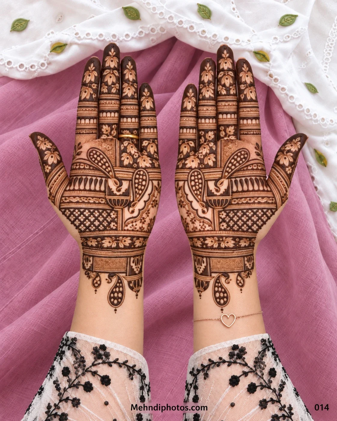 Symmetrical Diwali mehndi design on two front hands with paisley motifs, floral fingertips, lattice panels, geometric bands, and hanging wrist details.