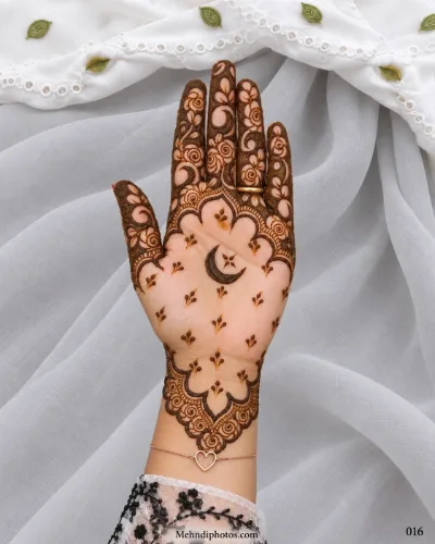 Eid front hand mehndi featuring a central crescent moon and star with tiny leafy sprigs, floral fingers, scalloped arches, and a rose wrist border.