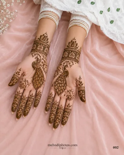 Elegant peacock mehndi design with floral and leafy patterns on both hands