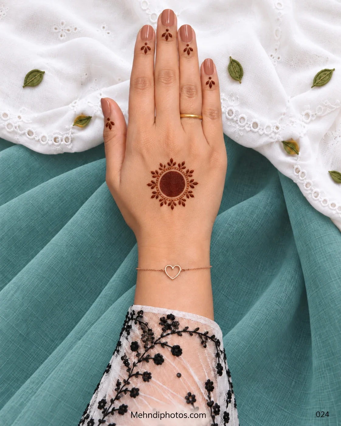 Minimal back-hand gol tikki mehndi with a teardrop leaf halo and tiny finger motifs