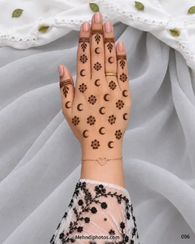 Minimal Eid back hand mehndi featuring repeating crescent moons, circular floral motifs, leafy finger accents, and fine decorative bands.