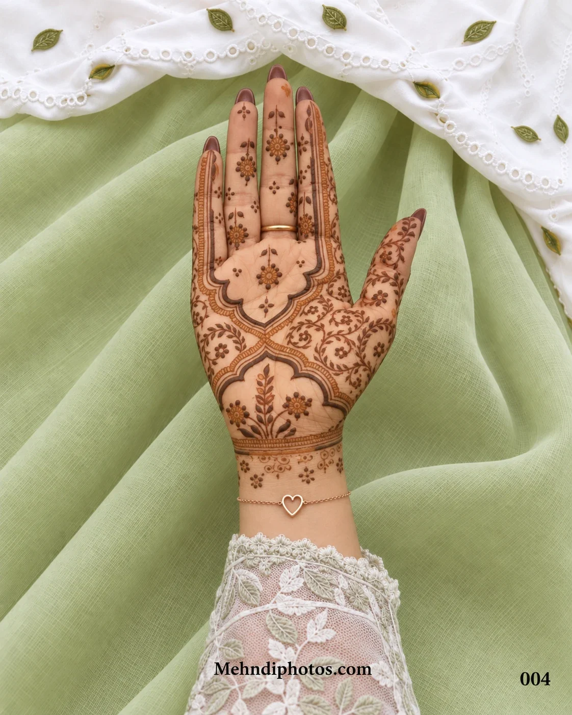 Front hand with a Muslim mehndi design featuring a framed open palm, small flowers, circular leafy vines and a botanical wrist panel.