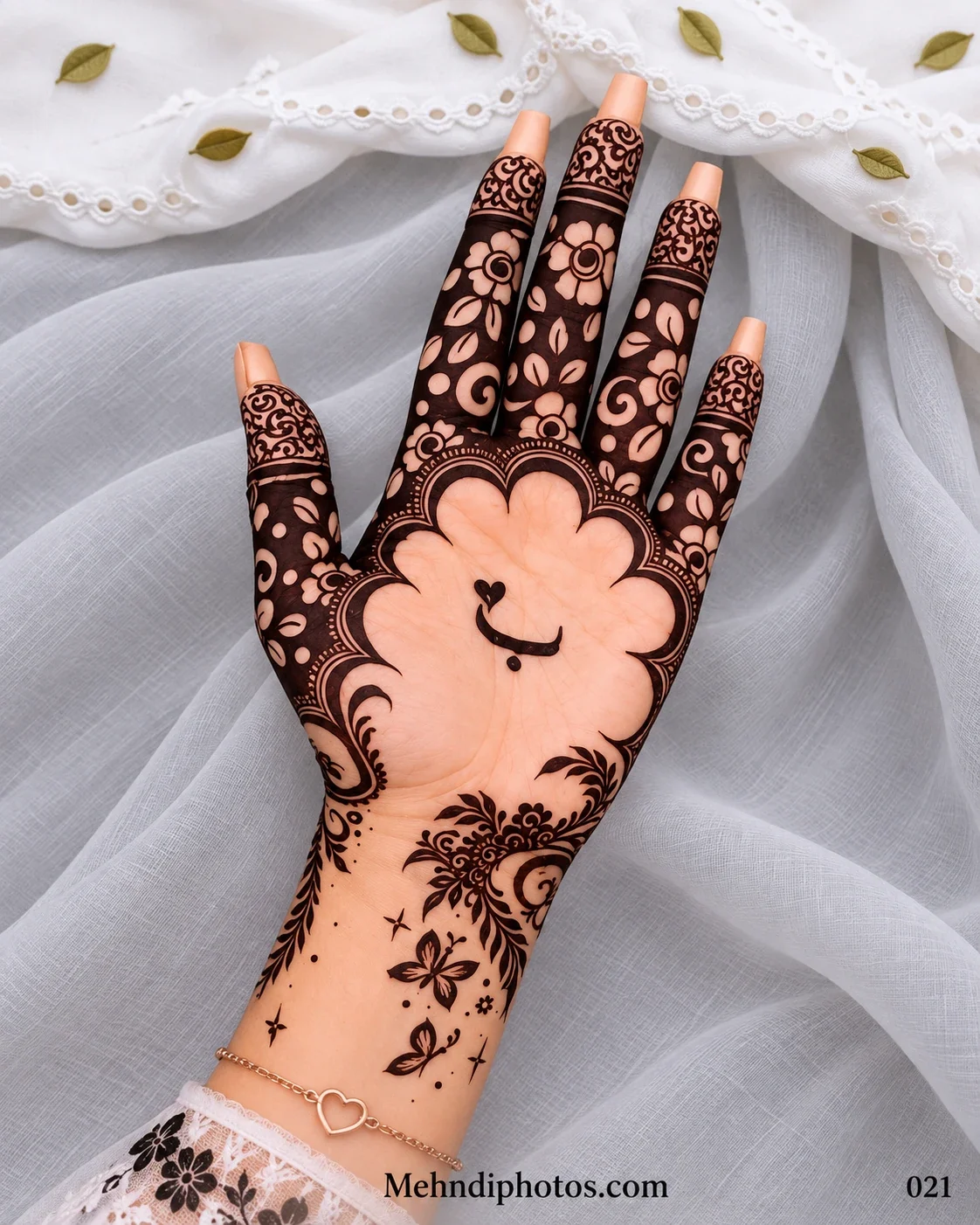 Eid front hand mehndi featuring an open palm with a heart-and-smile motif, scalloped floral frame, dark flower-filled fingers, vines, and butterflies.