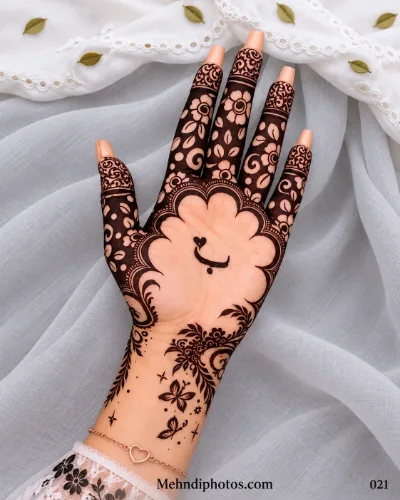 Eid front hand mehndi featuring an open palm with a heart-and-smile motif, scalloped floral frame, dark flower-filled fingers, vines, and butterflies.