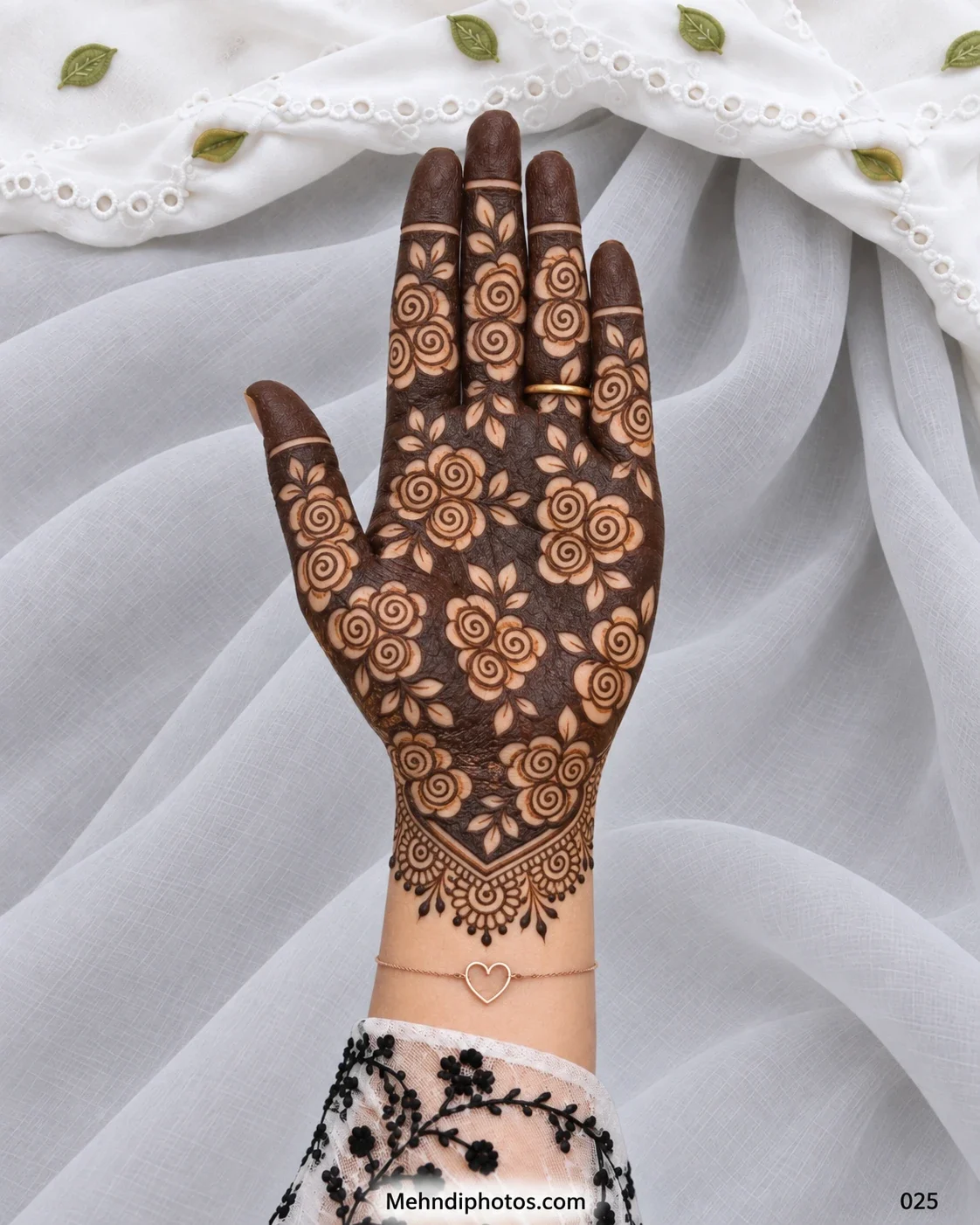 Full palm Eid mehndi with spiral roses and leaves over a dark henna background, solid fingertips, and an ornate pointed wrist border.