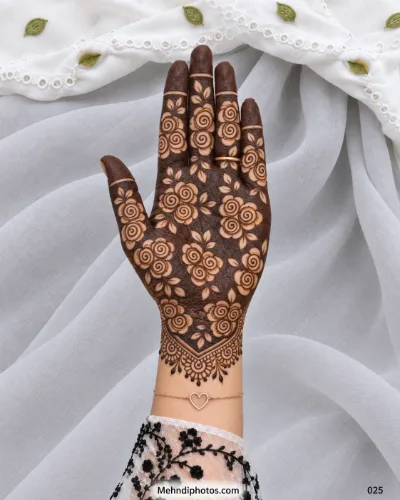 Full palm Eid mehndi with spiral roses and leaves over a dark henna background, solid fingertips, and an ornate pointed wrist border.
