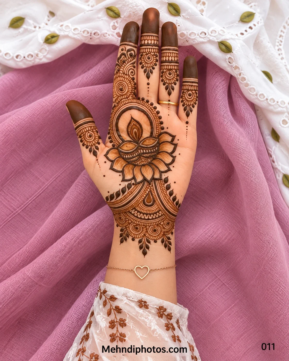 Diwali front hand mehndi design with a shaded diya on lotus petals, circular mandala frame, sunburst finger motifs, dark tips, and an ornate wrist.