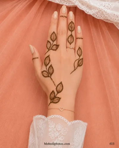Back hand with minimal outlined leaf branches, fine vein details and delicate dotted mehndi bands around selected fingers.